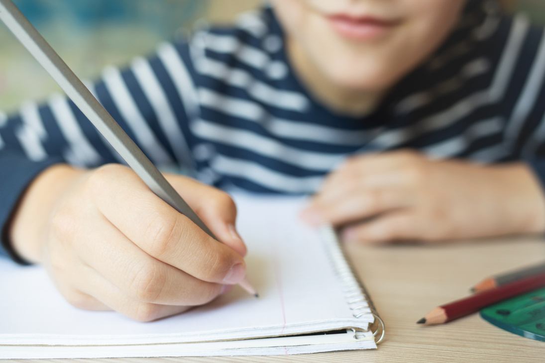 Kid writing in notebook.
